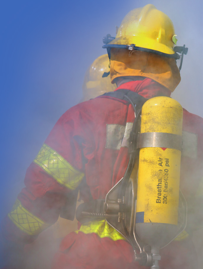 Firefighter in full gear and breathing apparatus amid smoke